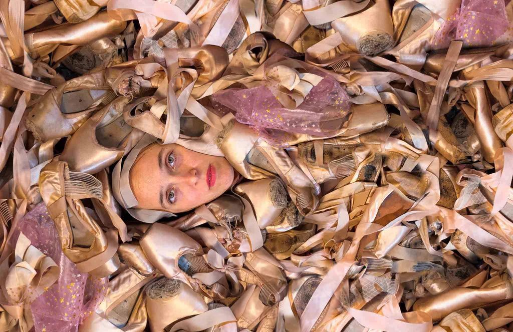 Martina immersed in a bathtub filled with pointe shoes, from LAGO